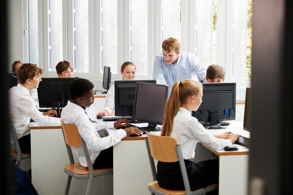 teenage students on computers in classroom