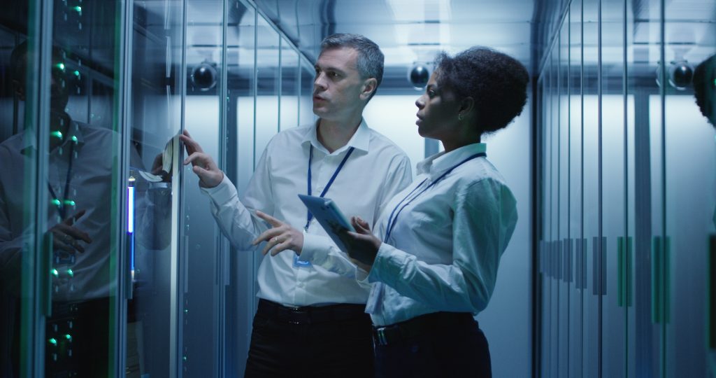 man and woman using devices diagnosing server hardware