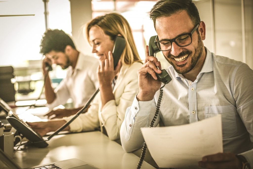 people in operations center talking on phone to clients and customers