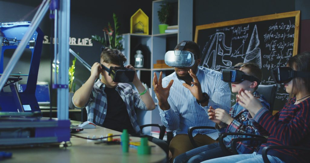 male teacher with students using VR