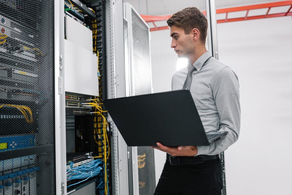 school ICT engineer in data center with laptop