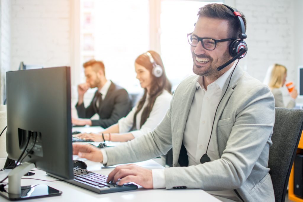 cheerful technical operator with headphones talking to customer