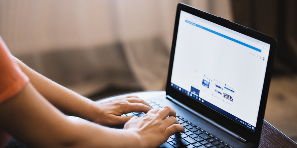 Hands typing on a laptop