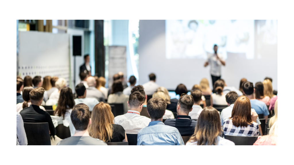 People sat in a room listening at a conference